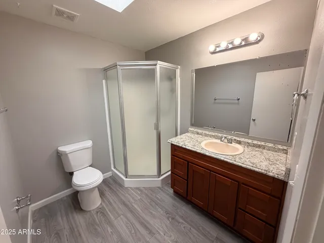 a bathroom with a granite countertop sink toilet and shower