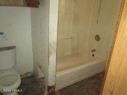 502 South Hennessy Road Yakima, WA 98908 - Photo 10 of 17 a bathroom with a granite countertop toilet and a bathtub