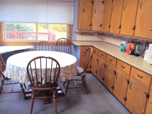 a kitchen with stainless steel appliances a table chairs in it and a window