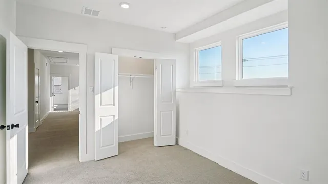 an empty room with closet and wooden door