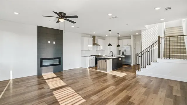 a large kitchen with stainless steel appliances kitchen island a large counter top a sink appliances and cabinets