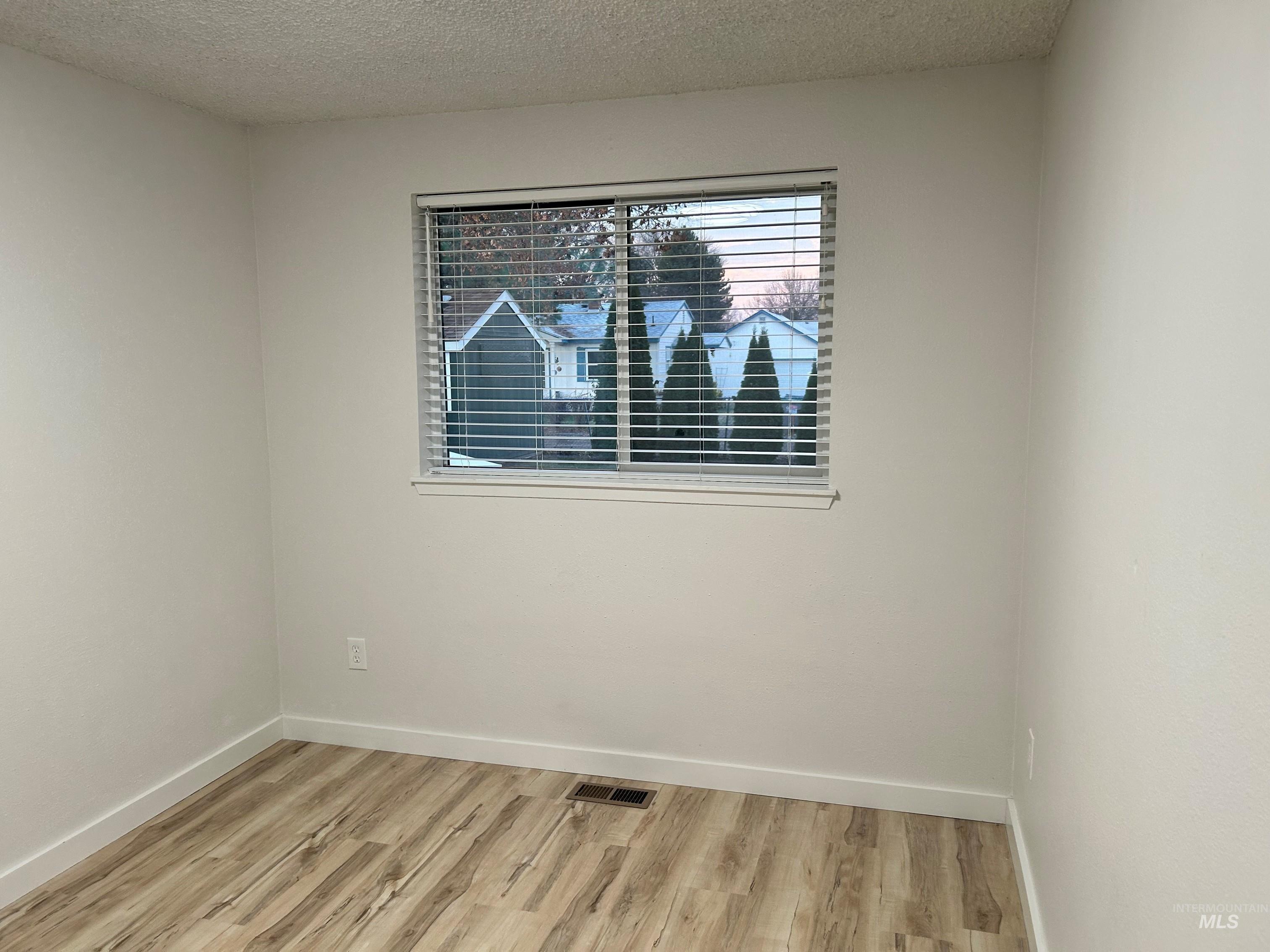 3897 South Yorktown Way Boise, ID 83706 - Photo 18 of 23 Empty room with a textured ceiling and light wood-type flooring