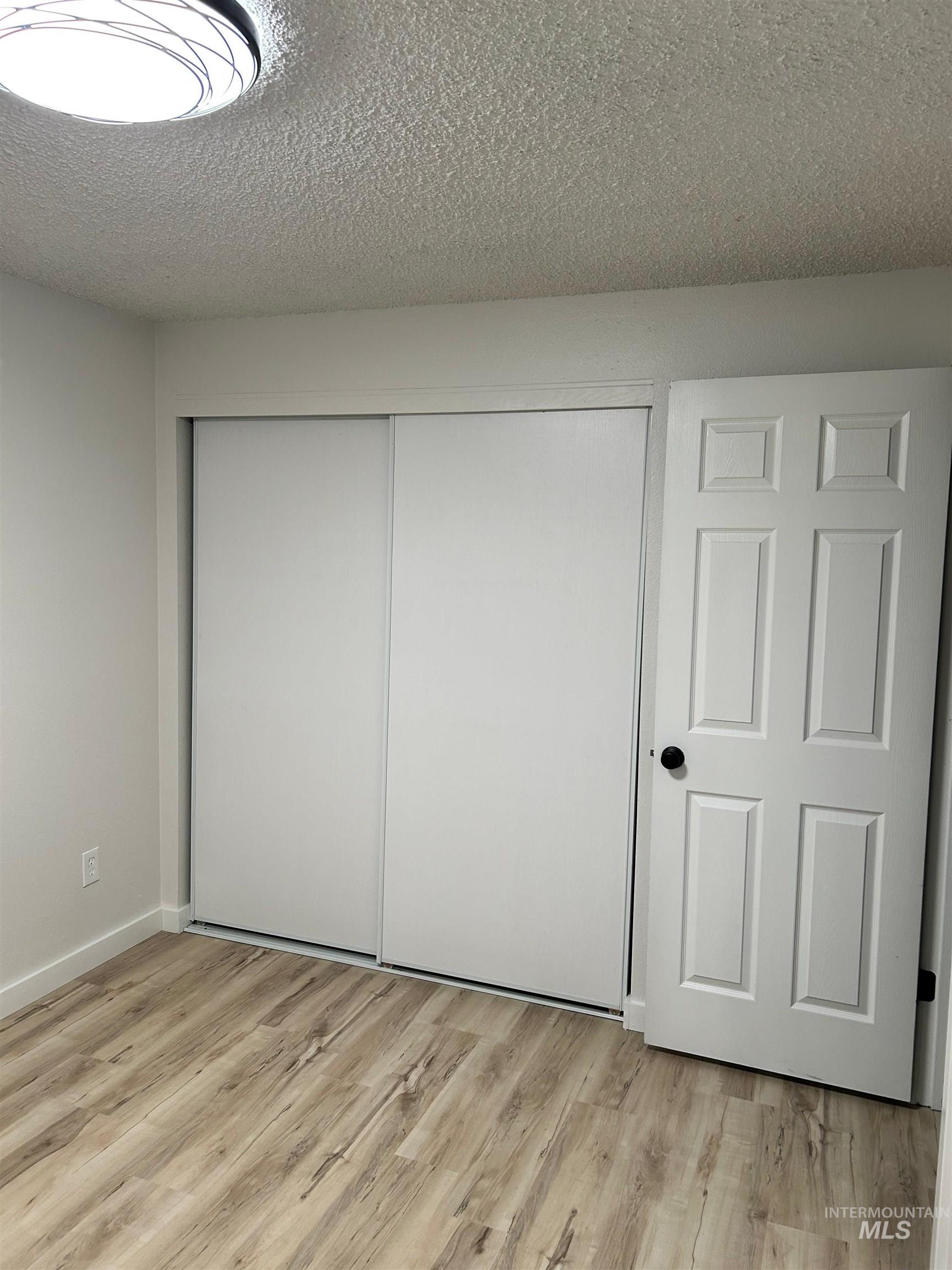 3897 South Yorktown Way Boise, ID 83706 - Photo 19 of 23 Unfurnished bedroom with a closet, light wood-type flooring, and a textured ceiling