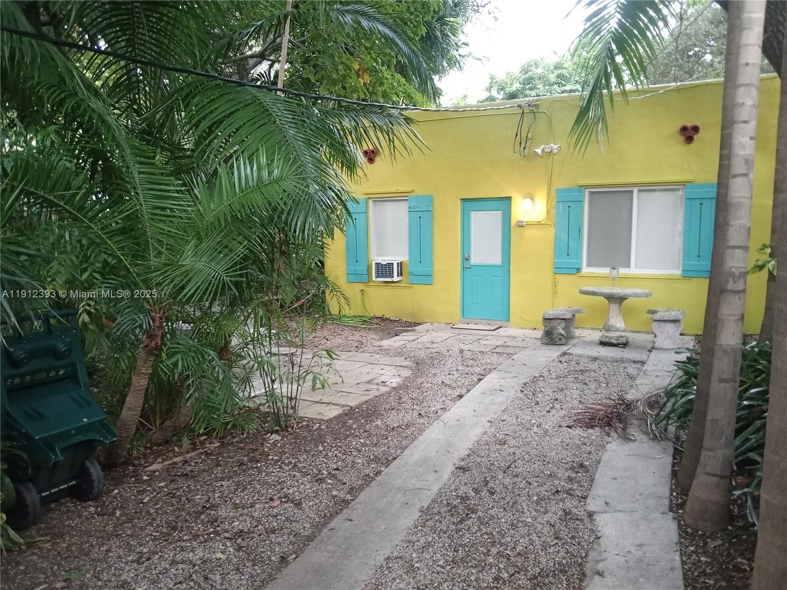 front view of a house with a yard and potted plants