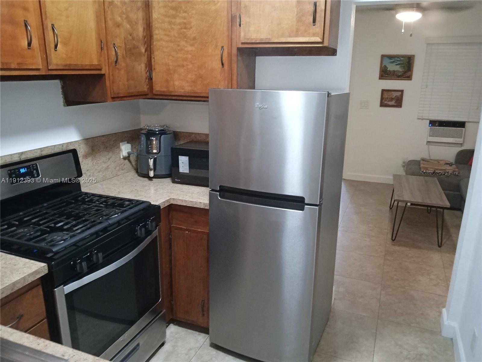 1906 Tigertail Avenue Miami, FL 33133 - Photo 2 of 17 a kitchen with stainless steel appliances granite countertop a refrigerator and a stove