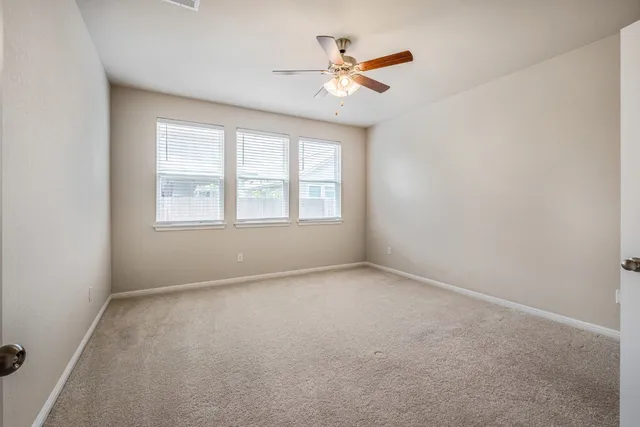 an empty room with a window and a fan
