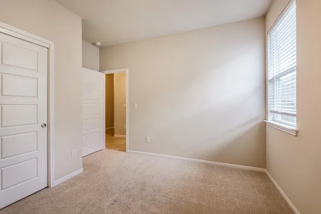 an empty room with windows and closet