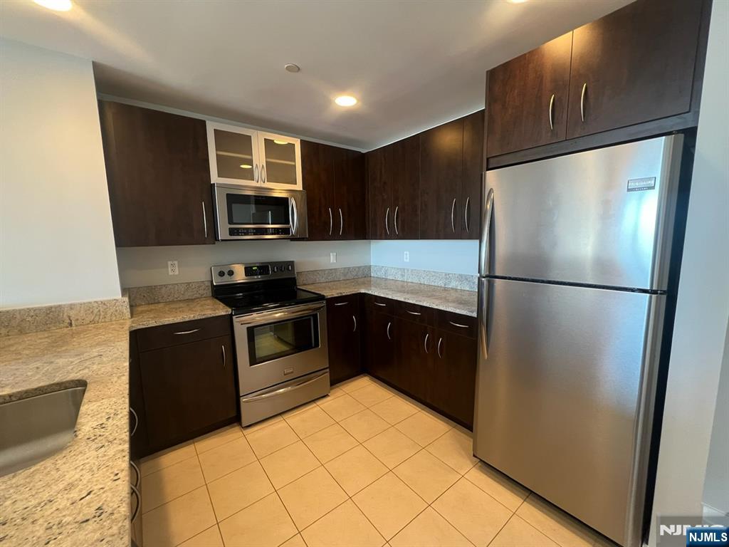 305 Palisade Avenue, Unit 208 Cliffside Park, NJ 07010 - Photo 15 of 16 a kitchen with a refrigerator and a stove top oven