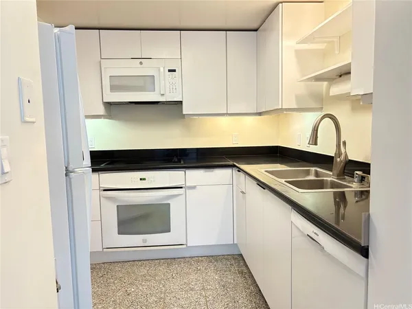 a view of a kitchen with sink microwave and cabinets