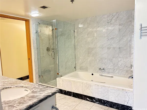 a bathroom with a granite countertop sink and a bathtub