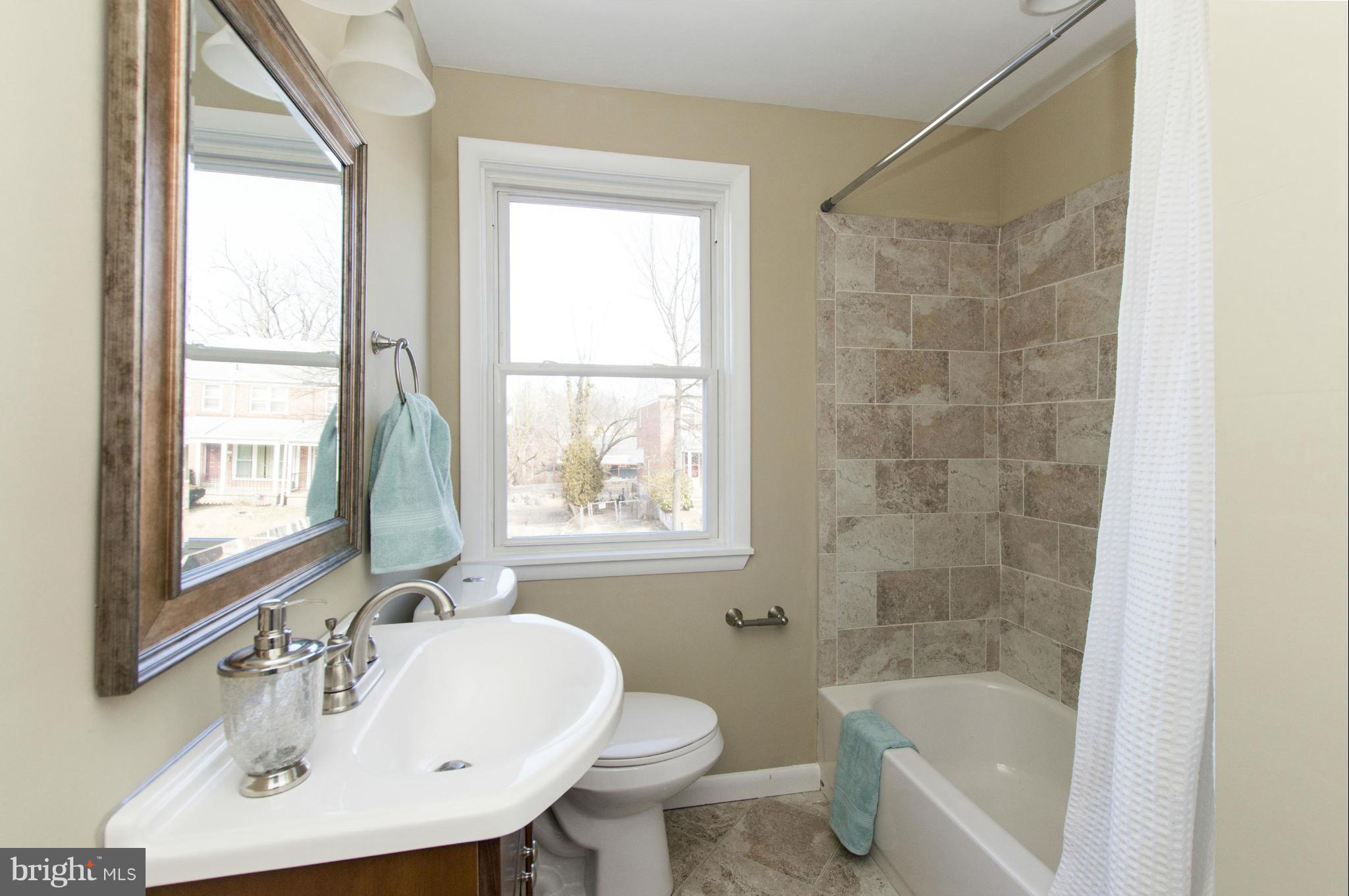1111 Hollen Road Baltimore, MD 21239 - Photo 13 of 30 a bathroom with a sink mirror bathtub and toilet