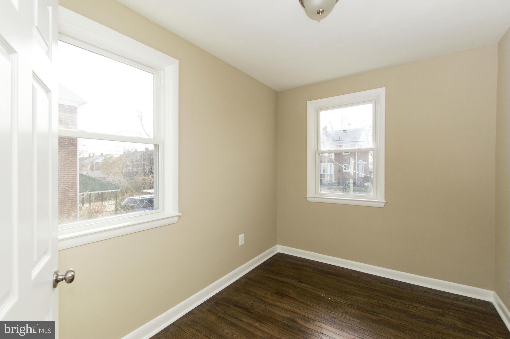 1111 Hollen Road Baltimore, MD 21239 - Photo 16 of 30 a view of an empty room with wooden floor and a window