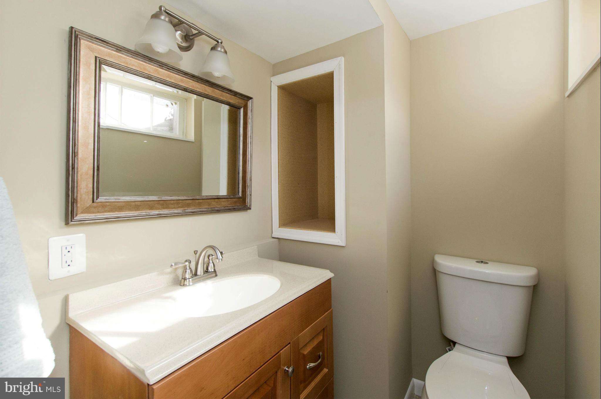 1111 Hollen Road Baltimore, MD 21239 - Photo 20 of 30 a bathroom with a toilet sink and mirror
