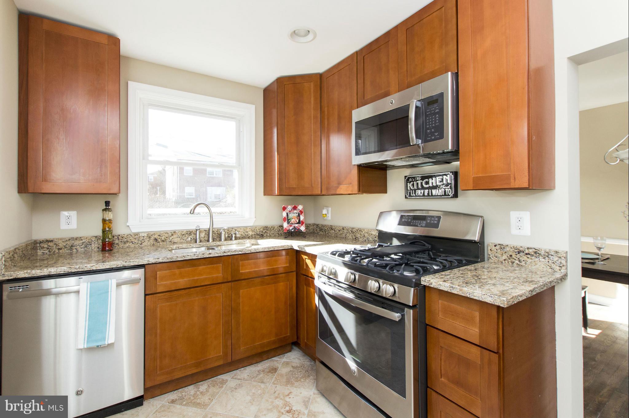 1111 Hollen Road Baltimore, MD 21239 - Photo 3 of 30 a kitchen with stainless steel appliances granite countertop a sink stove and microwave