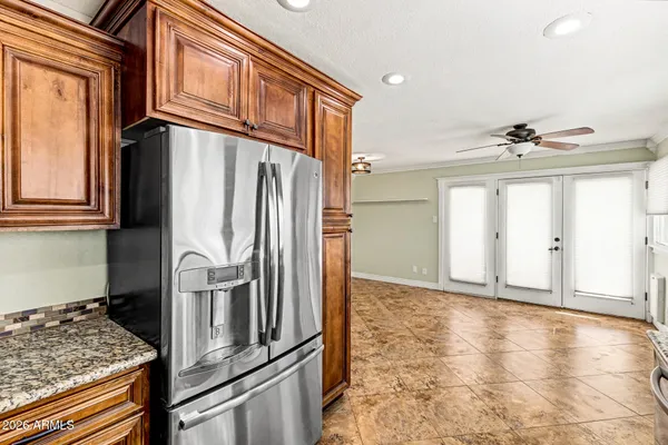 a view of a refrigerator in kitchen and an empty room