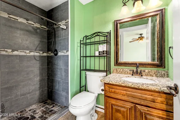 a bathroom with a granite countertop toilet sink and shower