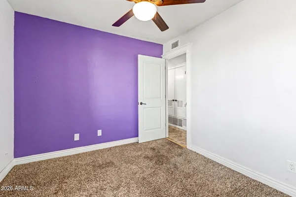 an empty room with a ceiling fan and painted walls