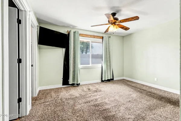 a view of an empty room with a ceiling fan