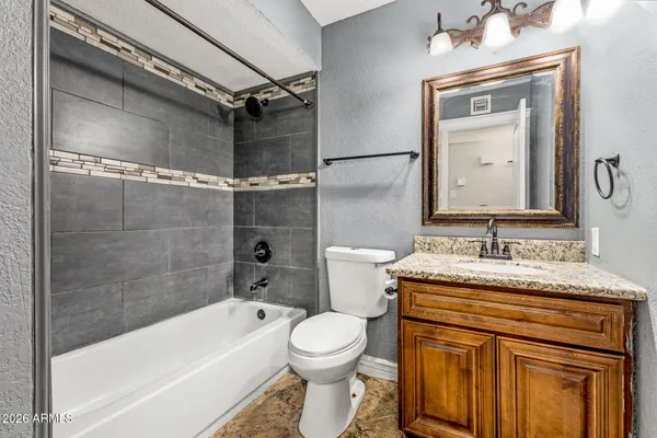 a bathroom with a granite countertop sink toilet and shower