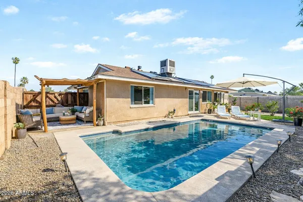 a view of a house with swimming pool and sitting area