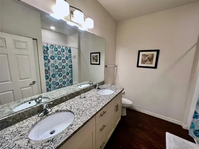 a bathroom with a granite countertop sink a mirror and a shower