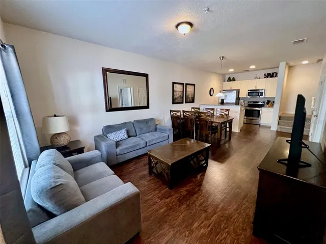 a living room with furniture flat screen tv and rug floor