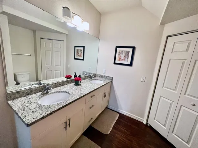 a bathroom with a granite countertop sink a mirror and a shower