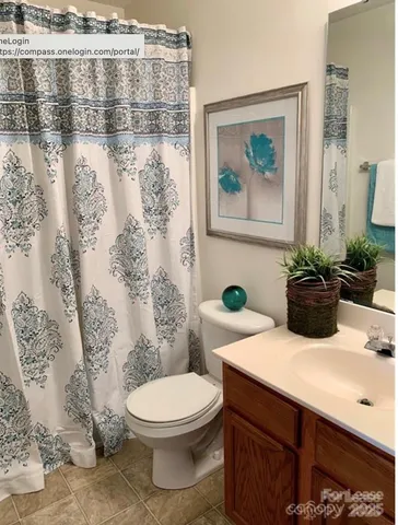 a bathroom with a toilet a sink and a shower curtain