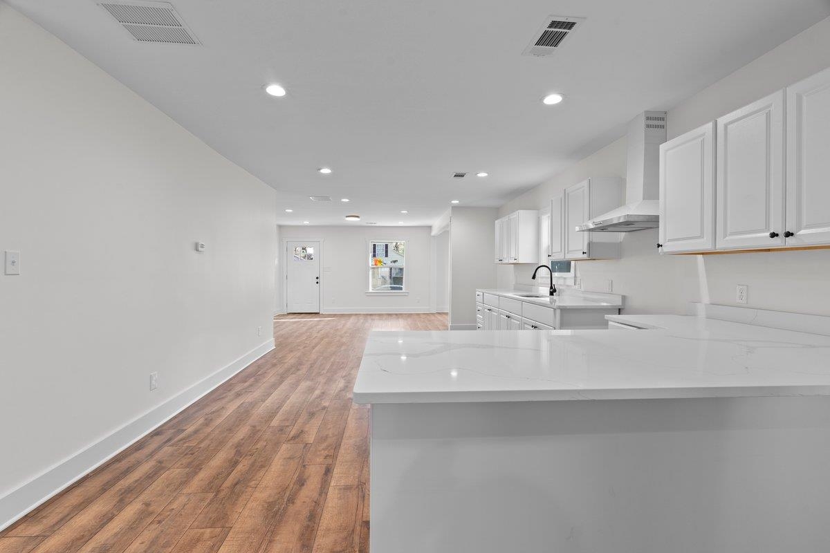 3220 Seminole Road Memphis, TN 38111 - Photo 11 of 23 Kitchen featuring white cabinetry, dark wood-style flooring, a peninsula, recessed lighting, and light stone counters
