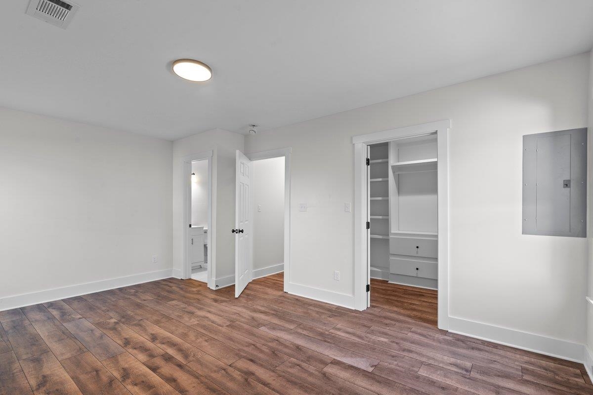 3220 Seminole Road Memphis, TN 38111 - Photo 12 of 23 Unfurnished bedroom featuring electric panel, a spacious closet, dark wood-style floors, and ensuite bath