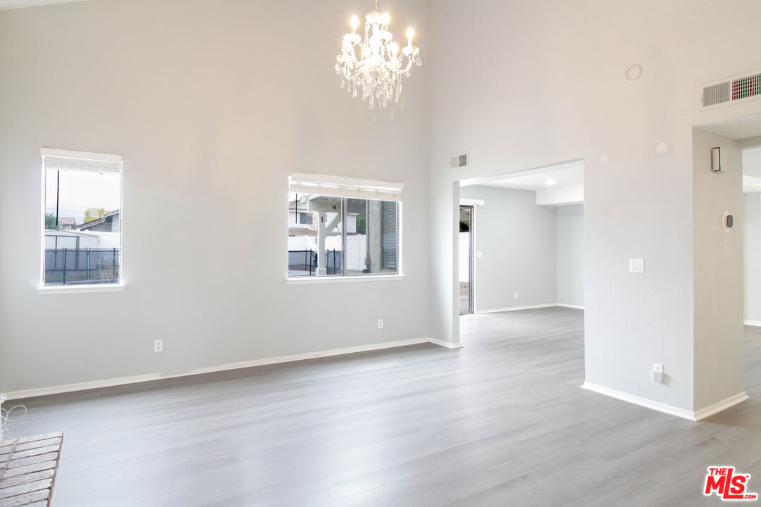 45809 Evelyn Court Lancaster, CA 93534 - Photo 3 of 24 an empty room with wooden floor chandelier and windows
