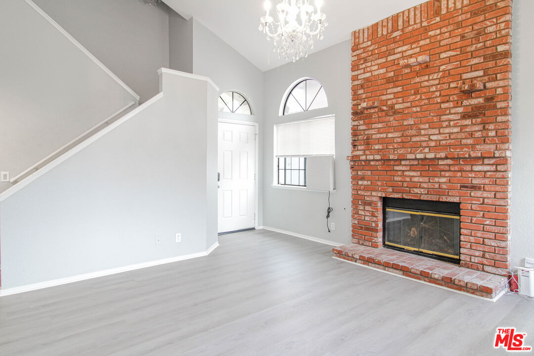 45809 Evelyn Court Lancaster, CA 93534 - Photo 4 of 24 a view of an empty room with wooden floor and a fireplace