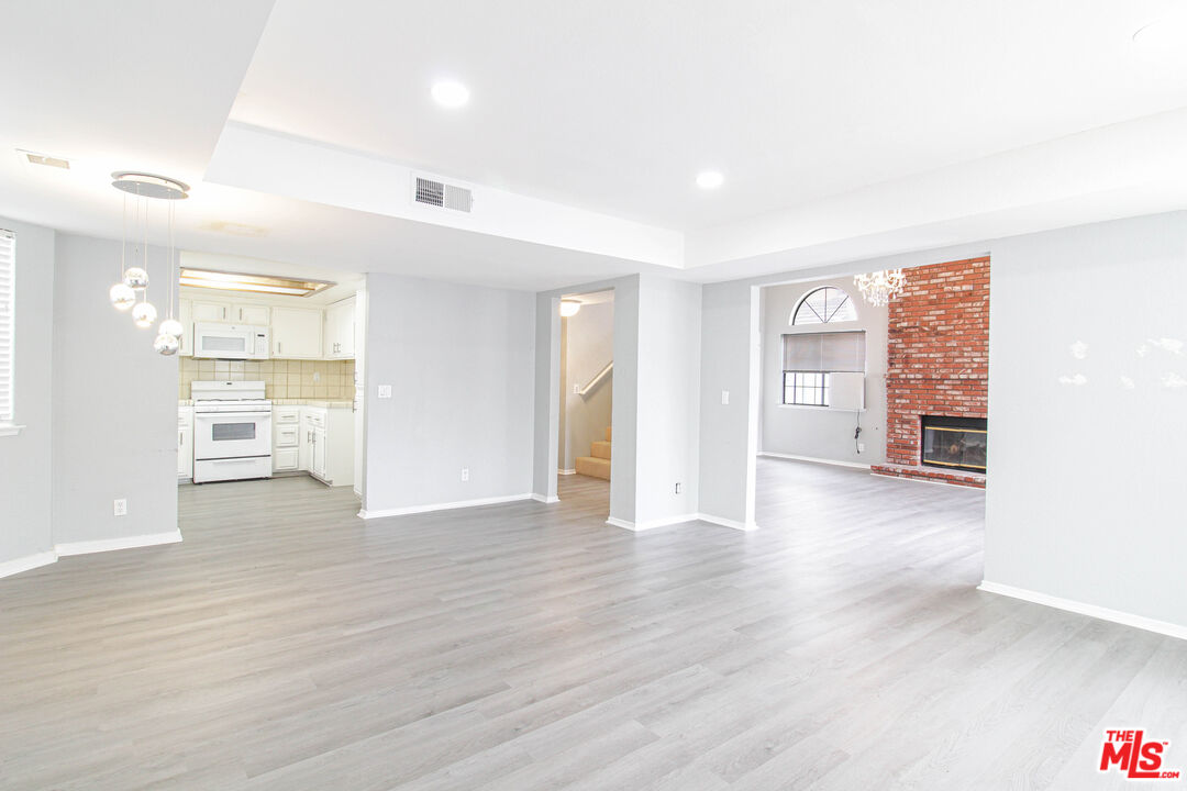 45809 Evelyn Court Lancaster, CA 93534 - Photo 7 of 24 a view of a kitchen with wooden floor and a refrigerator