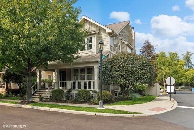 a front view of a house with a garden and trees