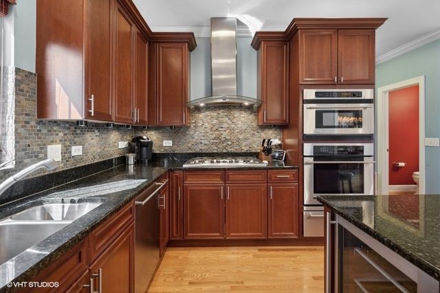 a kitchen with stainless steel appliances granite countertop a stove a sink and a microwave