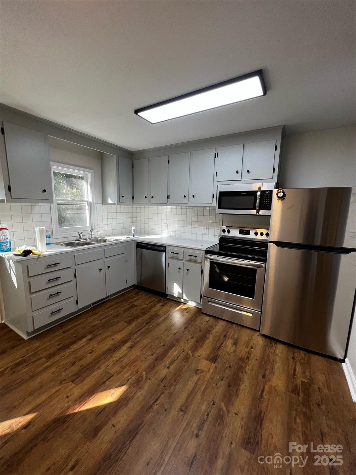120 South Morrow Avenue Albemarle, NC 28001 - Photo 2 of 6 a kitchen with stainless steel appliances a stove a sink a refrigerator white cabinets and wooden floor