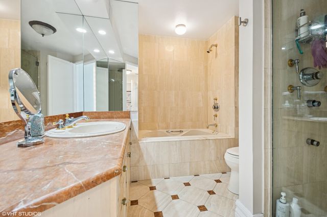 a bathroom with a granite countertop sink a toilet and shower