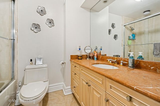 a bathroom with a granite countertop toilet sink and mirror
