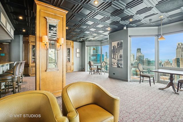 a living room with furniture a chandelier and a floor to ceiling window
