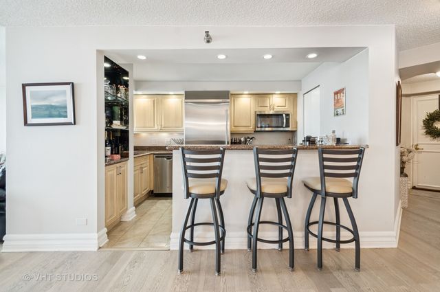a kitchen with cabinets and chairs