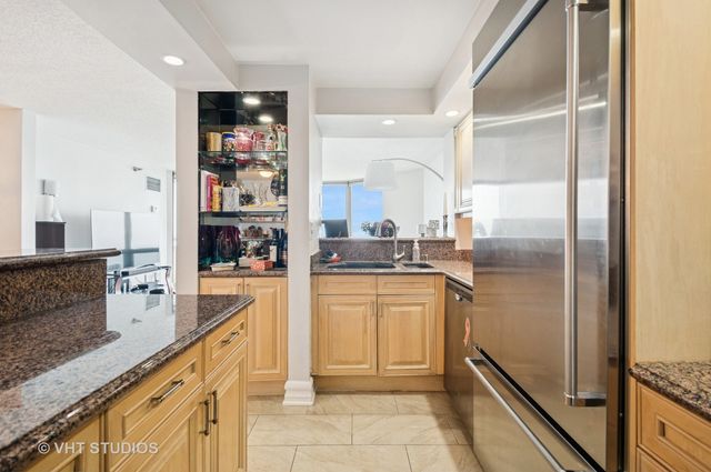 a kitchen with stainless steel appliances granite countertop a refrigerator and a sink