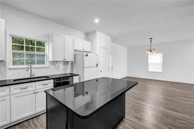 a kitchen with granite countertop a sink a center island and cabinets