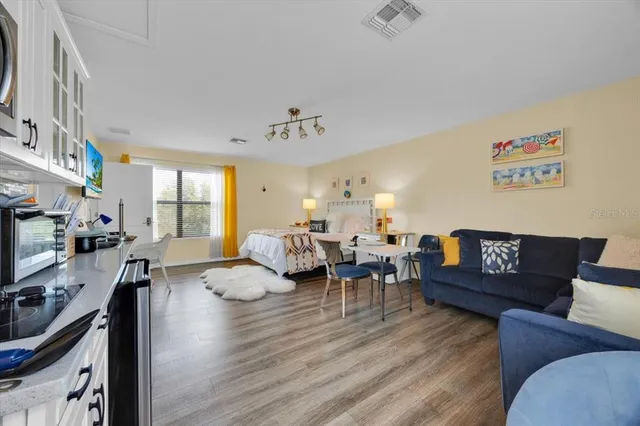 a living room with furniture kitchen view and a large window