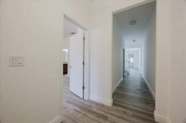 a view of a hallway with wooden floor