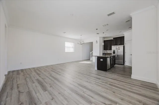 a kitchen with stainless steel appliances a refrigerator and a wooden floor