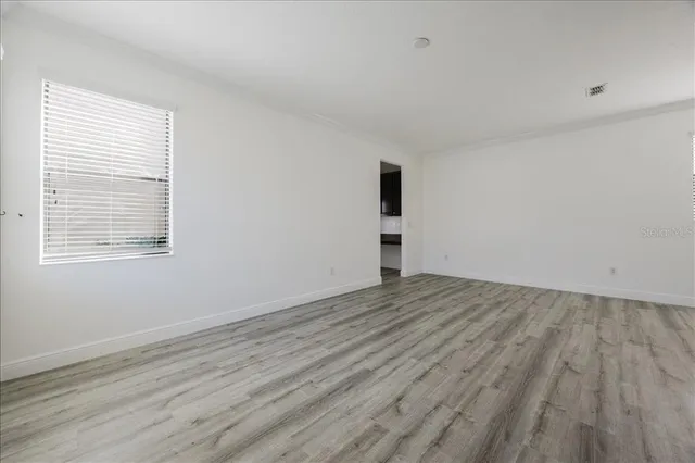 wooden floor in an empty room with a window