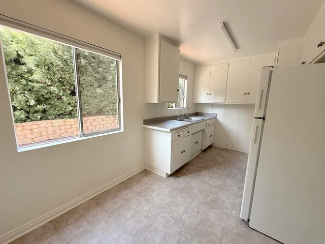 a kitchen with granite countertop a sink a stove a refrigerator and window