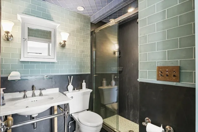 a bathroom with a sink mirror toilet and shower