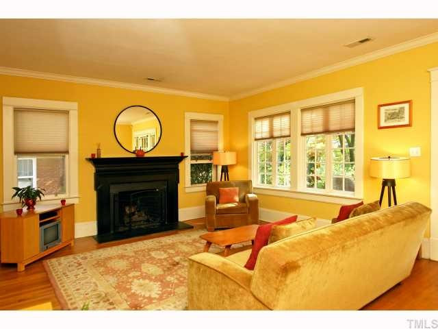 2708 Vanderbilt Avenue Raleigh, NC 27607 - Photo 4 of 12 The Living Room is a bright and cheerful space flooded with light from two side windows and two immense multi-light front windows reminiscent of English Cottages and the Craftsman style. Creamy yellow walls and stunning black fireplace complete the look!