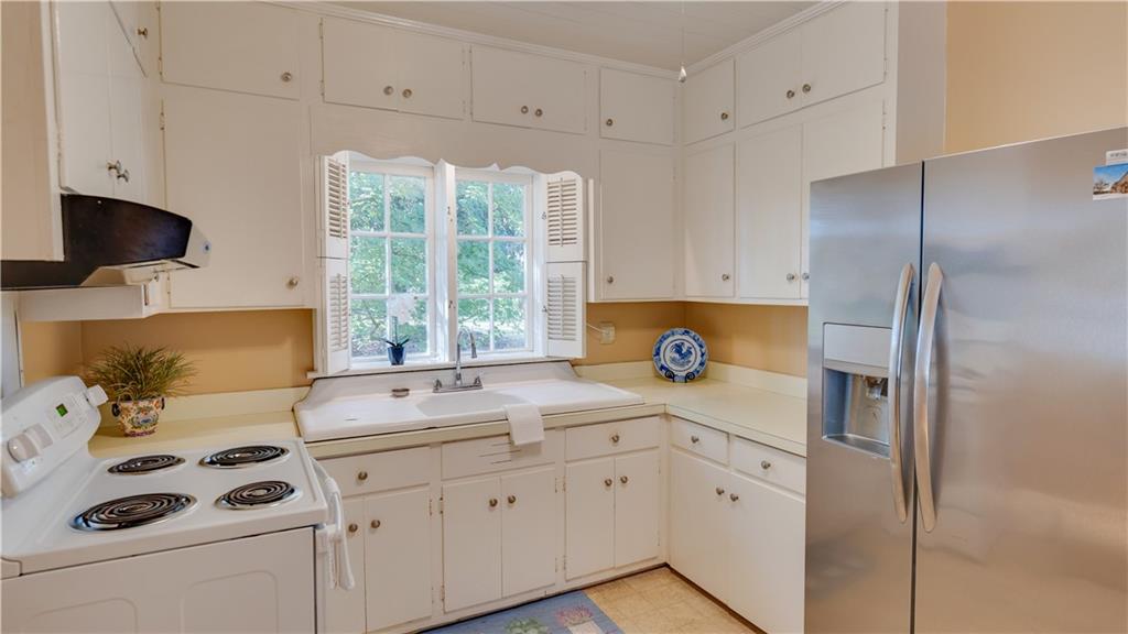 803 Forrest Avenue Tifton, GA 31794 - Photo 12 of 52 a kitchen with stainless steel appliances a sink a stove a refrigerator and cabinets